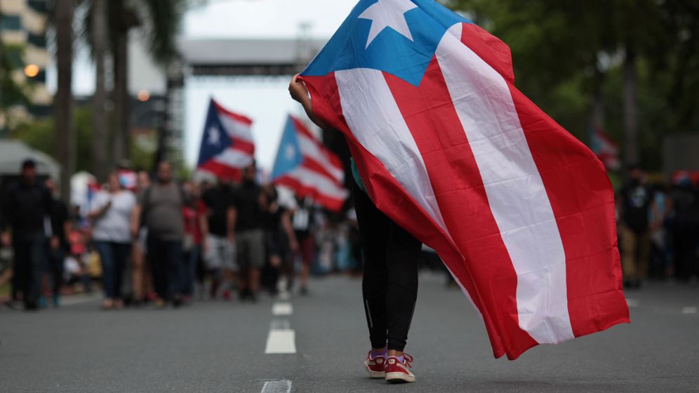 Foto: Una persona ondea una bandera de Puerto Rico en una manifestación contra las medidas de austeridad del Gobierno. (Reuters)